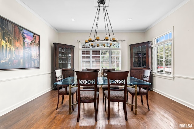 dining area with a chandelier, wood finished floors, baseboards, and crown molding