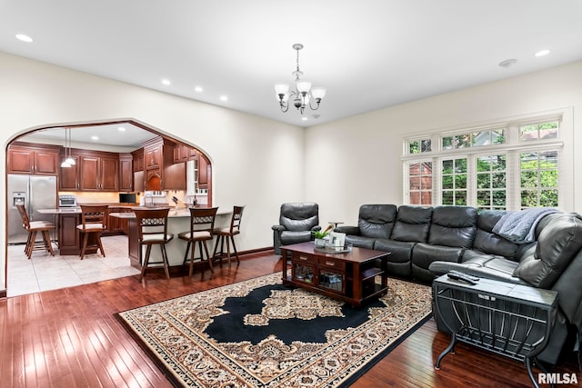 living area featuring arched walkways, a chandelier, hardwood / wood-style flooring, and recessed lighting