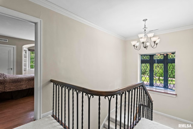 stairs with a chandelier, crown molding, baseboards, and arched walkways