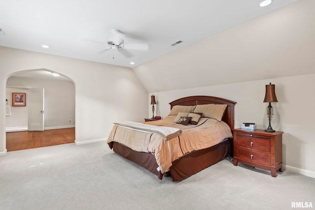 carpeted bedroom with arched walkways, recessed lighting, baseboards, vaulted ceiling, and ceiling fan