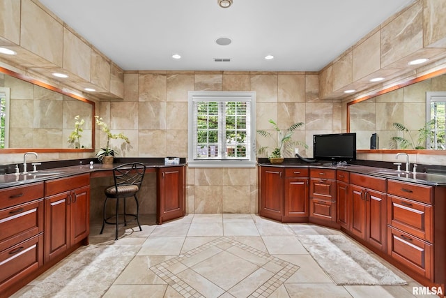 kitchen with a sink, tile walls, healthy amount of natural light, dark countertops, and recessed lighting