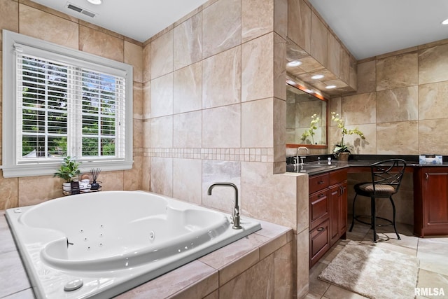 bathroom with tile walls, a whirlpool tub, vanity, and tile patterned floors