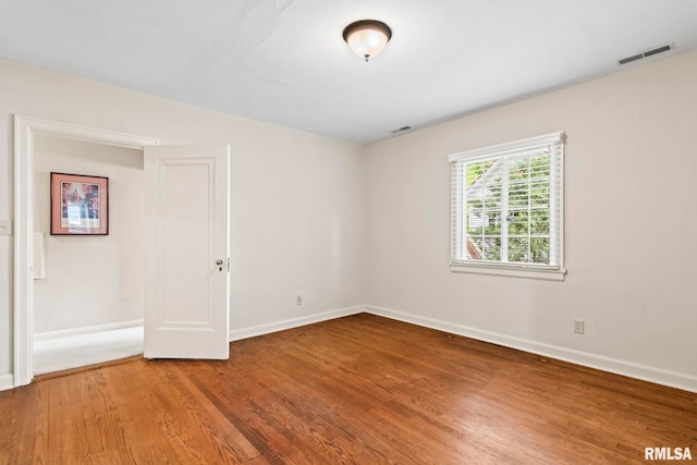 unfurnished room with wood finished floors and baseboards