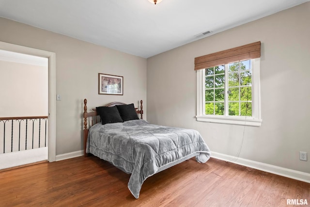 bedroom featuring baseboards and wood finished floors
