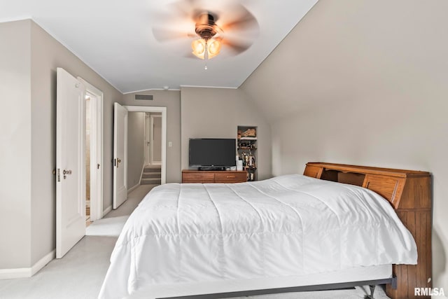 bedroom with lofted ceiling, baseboards, light colored carpet, and a ceiling fan