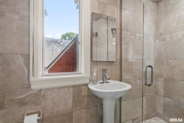 full bath featuring a stall shower and tile walls
