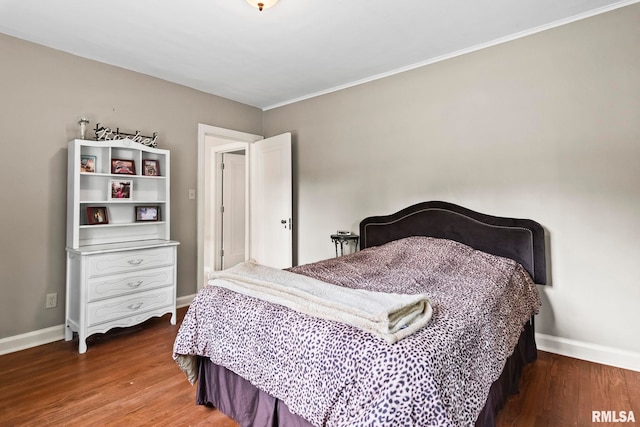 bedroom featuring wood finished floors, baseboards, and crown molding
