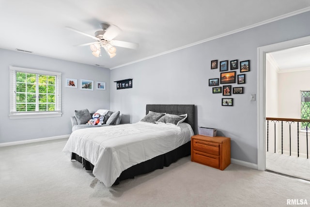 carpeted bedroom with baseboards, crown molding, and ceiling fan