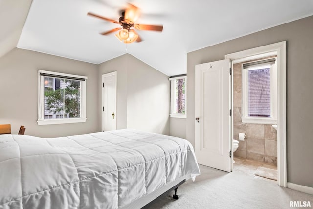 carpeted bedroom featuring connected bathroom, a ceiling fan, and tile walls