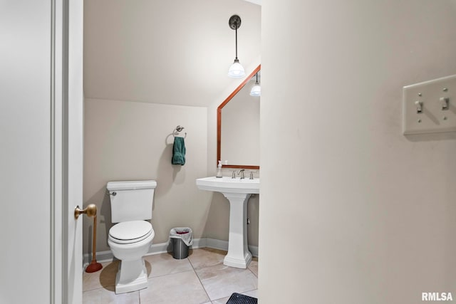 half bathroom with toilet, tile patterned floors, and a sink