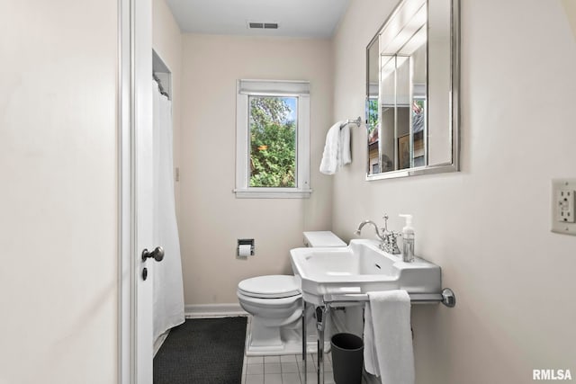 bathroom featuring tile patterned floors, toilet, baseboards, and curtained shower