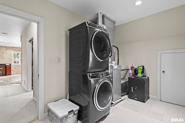 clothes washing area with stacked washer / drying machine, baseboards, and recessed lighting