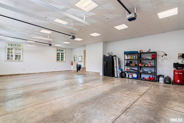 garage featuring black fridge and a garage door opener