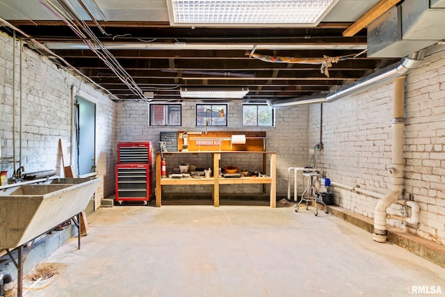 basement with a workshop area and brick wall
