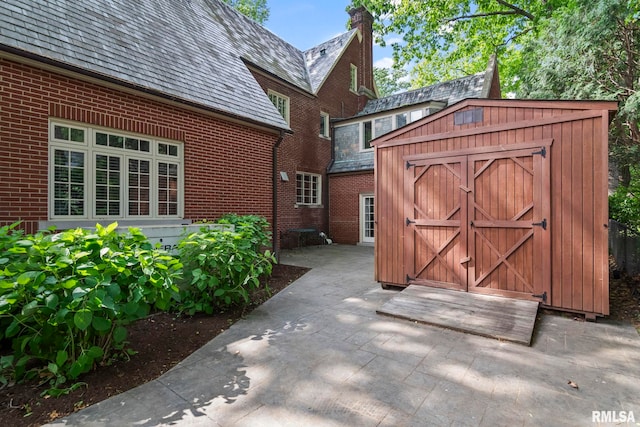 view of patio with a shed and an outdoor structure