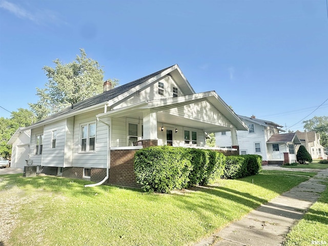 103 N Ohio Ave, Abingdon, IL 61410 - bungalow-style house featuring a front lawn, covered porch, cooling unit, a chimney, and a garage