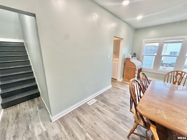 103 N Ohio Ave, Abingdon, IL 61410 - dining area with light wood-style floors, baseboards, stairway, and washer / dryer
