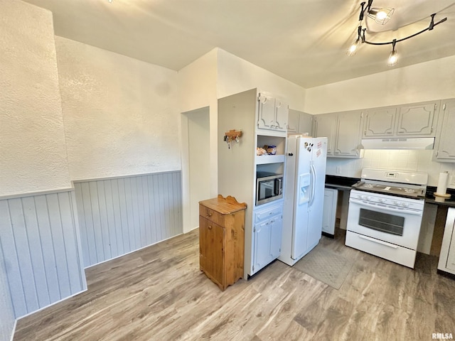 103 N Ohio Ave, Abingdon, IL 61410 - kitchen featuring white appliances, light wood-type flooring, wainscoting, under cabinet range hood, and backsplash