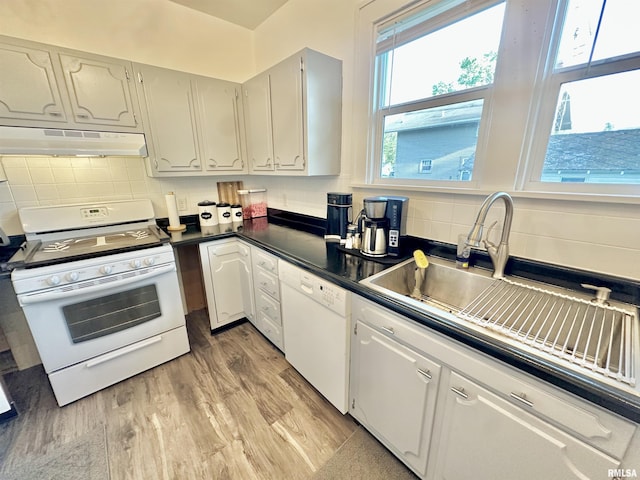 103 N Ohio Ave, Abingdon, IL 61410 - kitchen with under cabinet range hood, white appliances, tasteful backsplash, dark countertops, and a sink