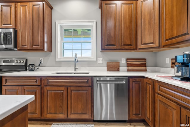 142 Oak Rd, Harrisburg, IL 62946 - kitchen with appliances with stainless steel finishes, a sink, light countertops, and brown cabinetry