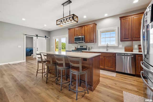 142 Oak Rd, Harrisburg, IL 62946 - kitchen featuring appliances with stainless steel finishes, a sink, a kitchen breakfast bar, a kitchen island, and light countertops