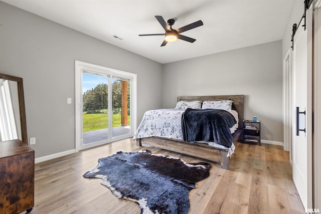 142 Oak Rd, Harrisburg, IL 62946 - bedroom with access to exterior, wood finished floors, a barn door, baseboards, and ceiling fan