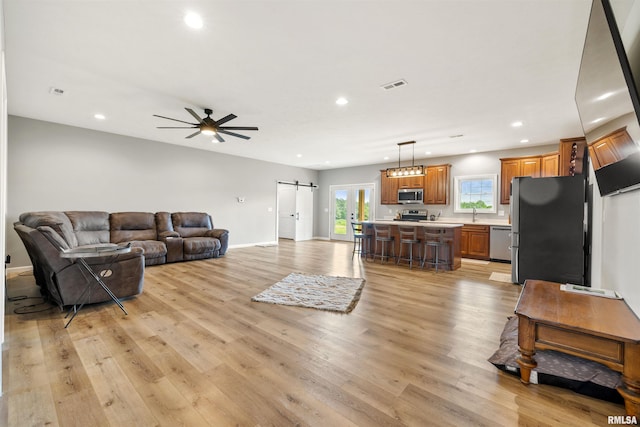 142 Oak Rd, Harrisburg, IL 62946 - living area with a barn door, recessed lighting, light wood-type flooring, a ceiling fan, and baseboards