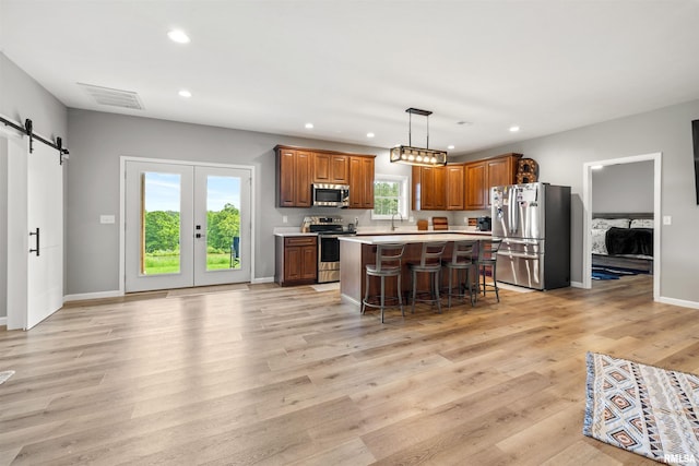 142 Oak Rd, Harrisburg, IL 62946 - kitchen featuring appliances with stainless steel finishes, a barn door, recessed lighting, light countertops, and a breakfast bar
