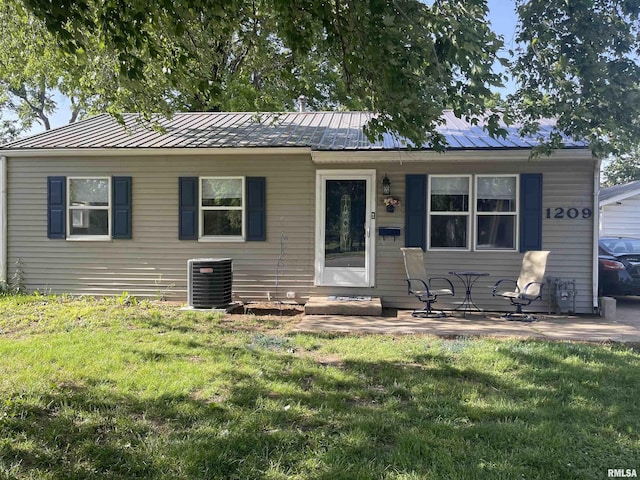 1209 W N Grand Ave, Springfield, IL 62704 - view of front of property featuring central AC unit, a front lawn, roof mounted solar panels, and metal roof