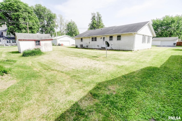 206 W N St, Assumption, IL 62510 - rear view of property featuring a garage, an outbuilding, and a lawn