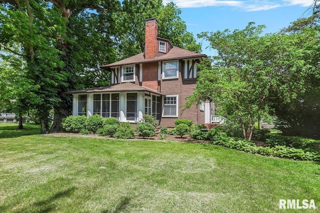 3 Duncan Park, Jacksonville, IL 62650 - view of front facade with a sunroom, a chimney, a front yard, and roof with shingles