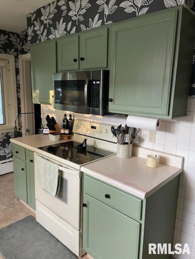 413 W Grant St, Pittsfield, IL 62363 - kitchen with green cabinetry, white electric range, stainless steel microwave, wallpapered walls, and light countertops