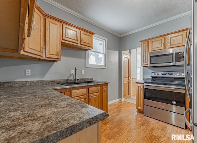 1507 4th St, Lincoln, IL 62656 - kitchen with stainless steel appliances, a sink, light wood-type flooring, ornamental molding, and dark countertops