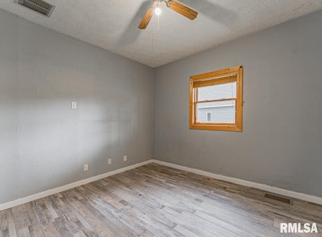 1507 4th St, Lincoln, IL 62656 - empty room with ceiling fan, wood finished floors, a textured ceiling, and baseboards