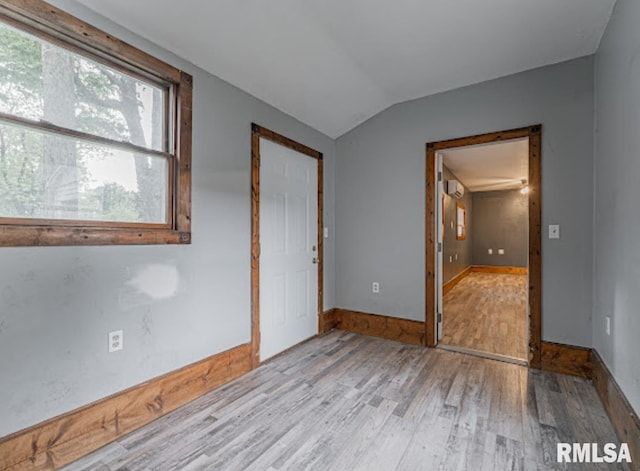 1507 4th St, Lincoln, IL 62656 - spare room with wood finished floors, vaulted ceiling, and baseboards