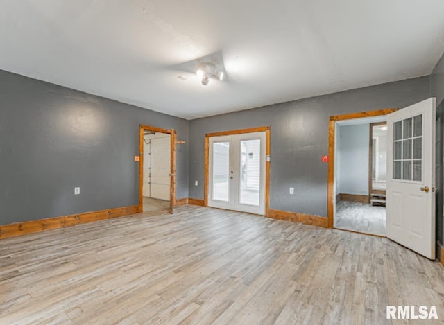1507 4th St, Lincoln, IL 62656 - empty room with light wood-style flooring, french doors, and baseboards