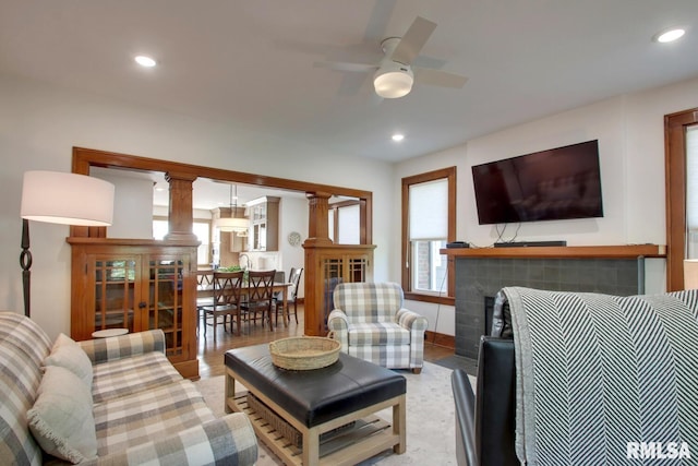 321 S 23rd St, Quincy, IL 62301 - living room with ceiling fan, a tiled fireplace, recessed lighting, light wood-type flooring, and ornate columns