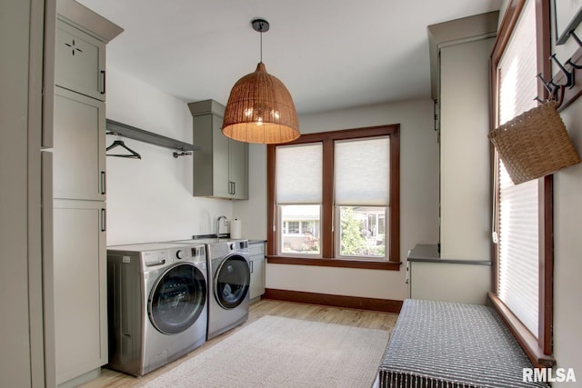 321 S 23rd St, Quincy, IL 62301 - laundry area with cabinet space, washer and dryer, plenty of natural light, and light wood-type flooring