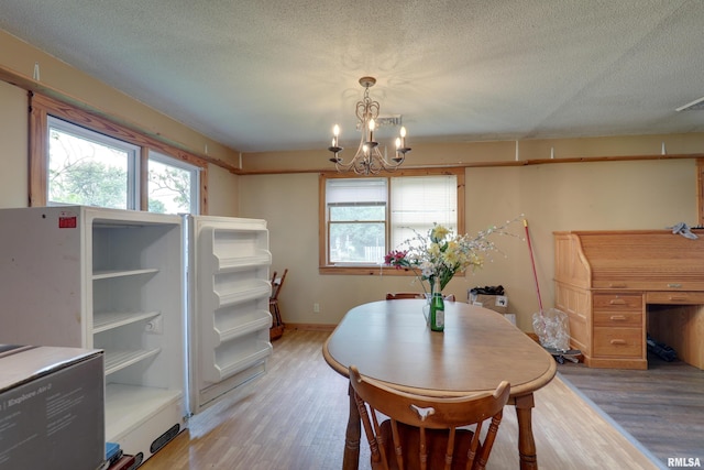 305 E Clay St, Pleasant Hill, IL 62366 - dining space with a chandelier, light wood finished floors, a textured ceiling, and baseboards