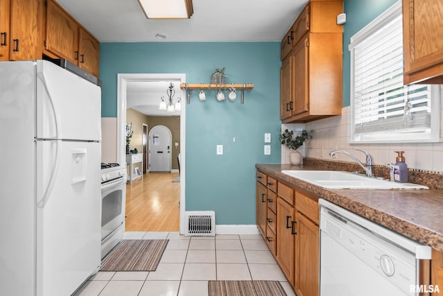 1622 W Cook St, Springfield, IL 62704 - kitchen featuring white appliances, a sink, dark countertops, decorative backsplash, and brown cabinetry