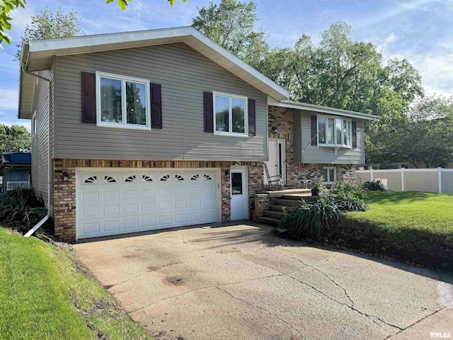 1666 Outrigger Rd, Galesburg, IL 61401 - raised ranch featuring a garage, driveway, and brick siding