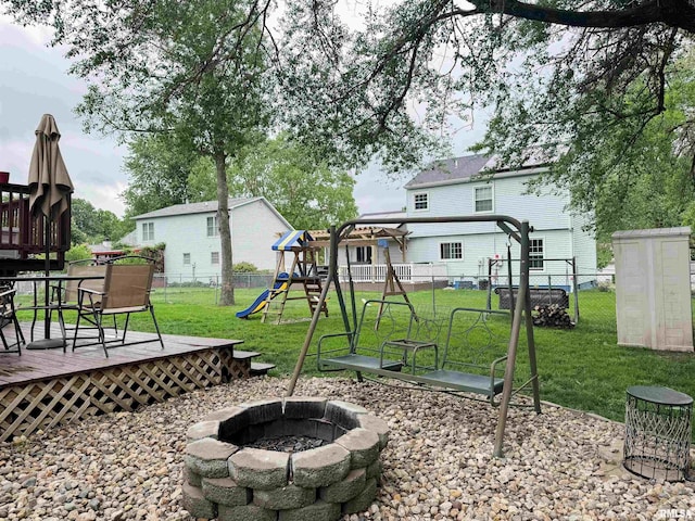 1666 Outrigger Rd, Galesburg, IL 61401 - view of yard with a fire pit, a deck, and a playground