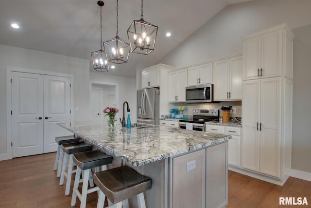 4619 Trinity Lakes Dr, Quincy, IL 62305 - kitchen featuring appliances with stainless steel finishes, a chandelier, a kitchen island with sink, white cabinets, and recessed lighting