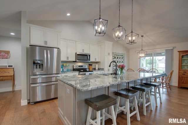 4619 Trinity Lakes Dr, Quincy, IL 62305 - kitchen with stainless steel appliances, a chandelier, a sink, a center island with sink, and white cabinetry