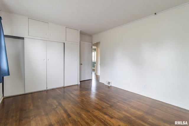 1520 W Losey St, Galesburg, IL 61401 - unfurnished bedroom featuring dark wood-style flooring, crown molding, a closet, and baseboards
