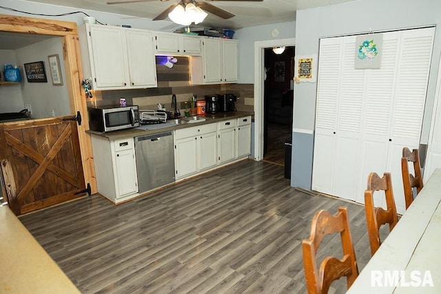607 E 3rd St, Kinmundy, IL 62854 - kitchen with stainless steel appliances, ceiling fan, dark wood-style floors, white cabinetry, and dark countertops