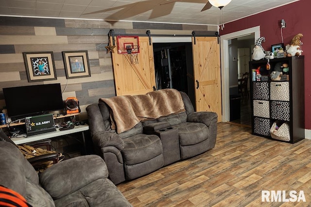 607 E 3rd St, Kinmundy, IL 62854 - living area featuring a barn door, wood finished floors, ceiling fan, and wood walls