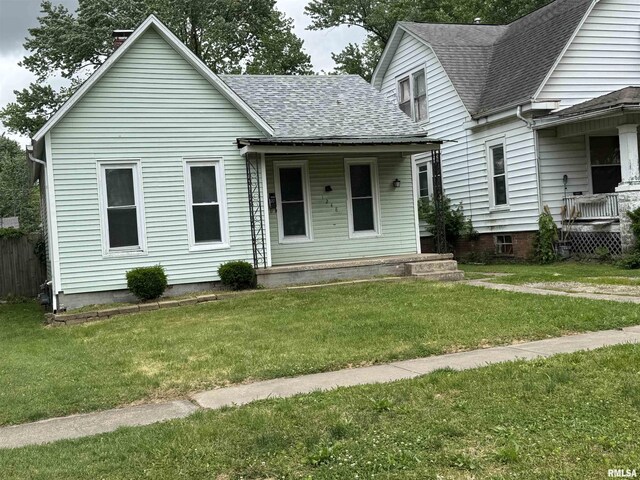 1248 N Ledlie Ave, Springfield, IL 62702 - view of front of home with a porch, a shingled roof, a front yard, and a chimney
