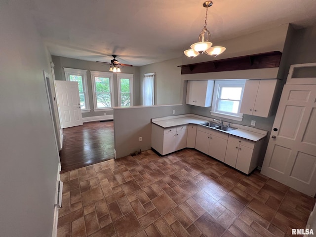 1312 N 3rd St, Springfield, IL 62702 - kitchen with light countertops, white cabinets, a ceiling fan, decorative light fixtures, and a sink