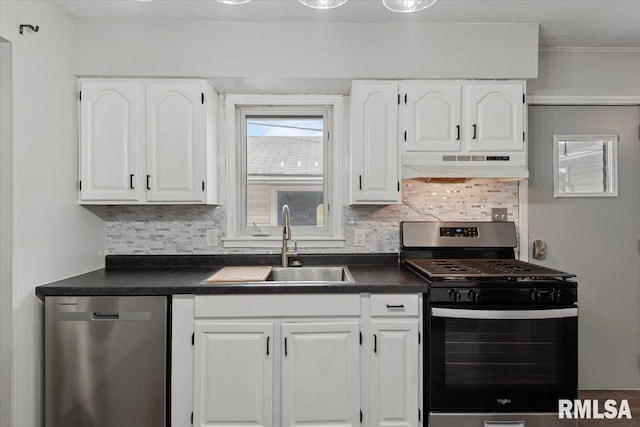 8 Melody Ln, Springfield, IL 62702 - kitchen featuring appliances with stainless steel finishes, under cabinet range hood, a sink, dark countertops, and white cabinetry